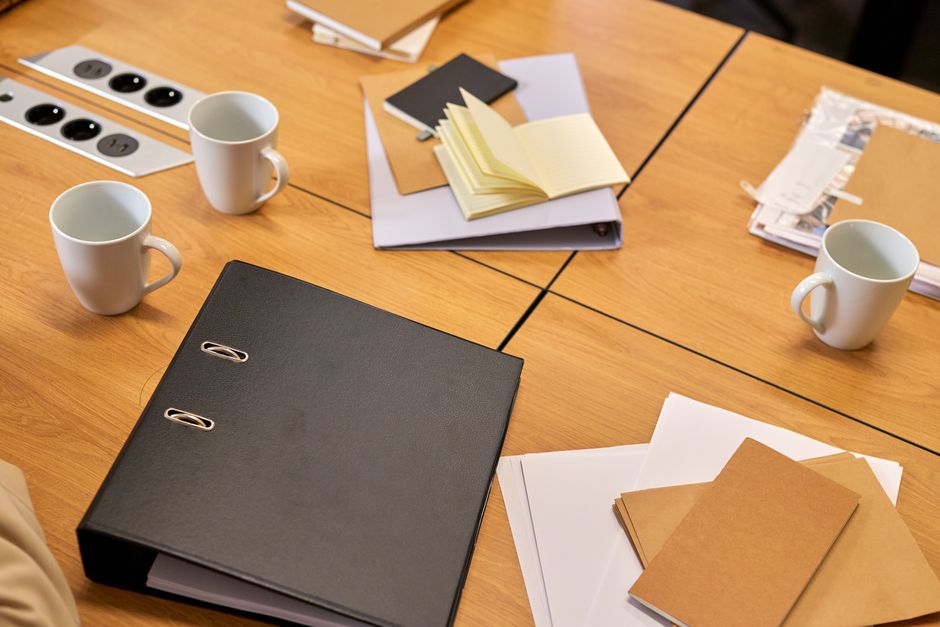 Dossiers et classeur sur une table de travail, suivi du temps passé