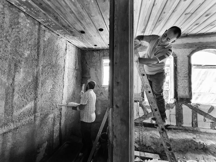 Chantier de rénovation intérieure, artisans enduisant les murs
