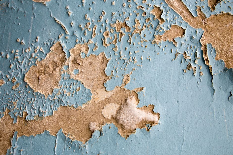 Mur dégradé par l'humidité, peinture écaillée après des désordres de construction