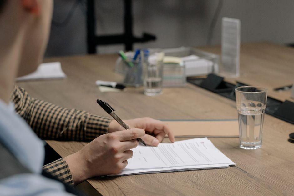 Client relisant et signant un contrat sur un bureau