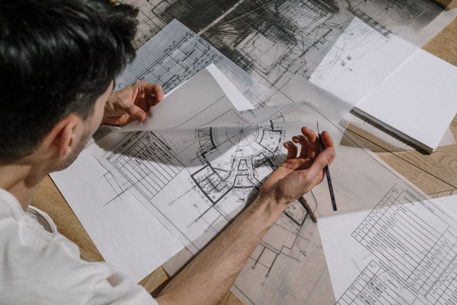 Plans d'architecte annotés étalés sur une table, dossier de permis de construire