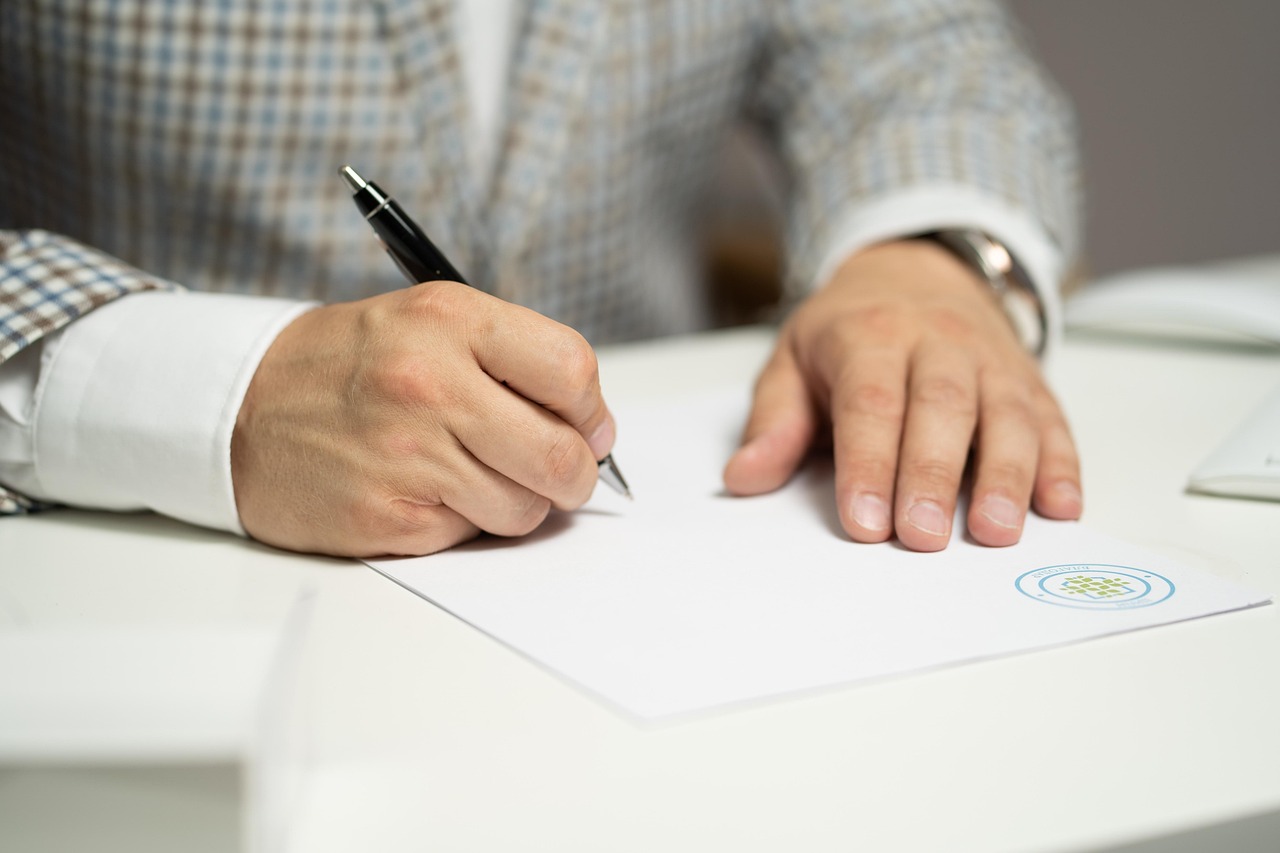 Signature d'un document sur un bureau clair